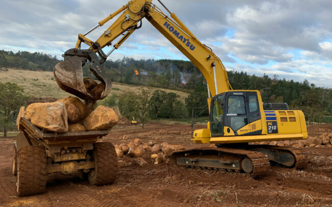 Construction equipment moving large boulders
